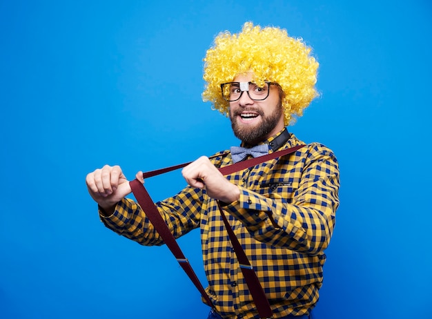 Free photo man with wig pulling suspenders