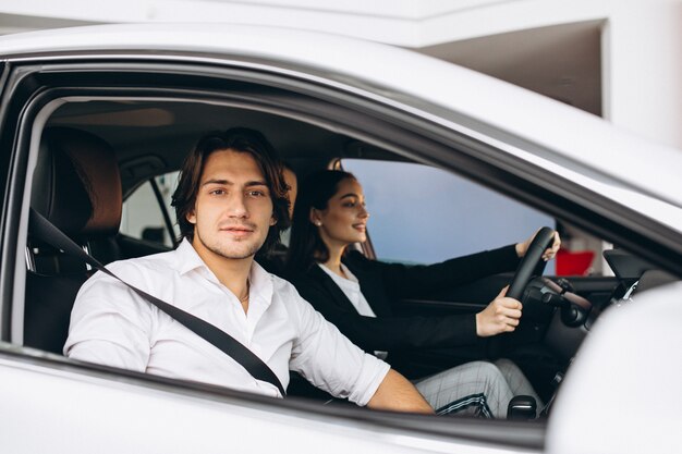 Man with woman in a car showroom choosing a car