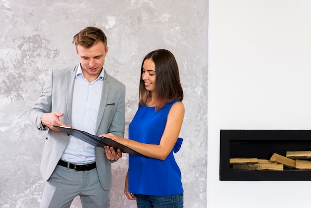 Man and woman analysing a clipboard 