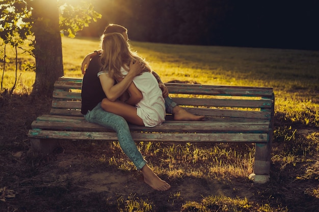 a man and a woman are sitting on a bench and kissing