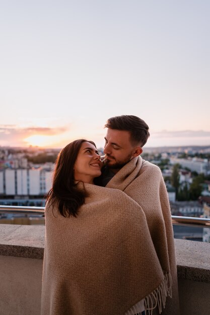 街の夕暮れ時のバルコニーの男女