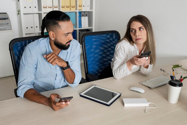 男性と女性が自分の携帯電話にはまっている