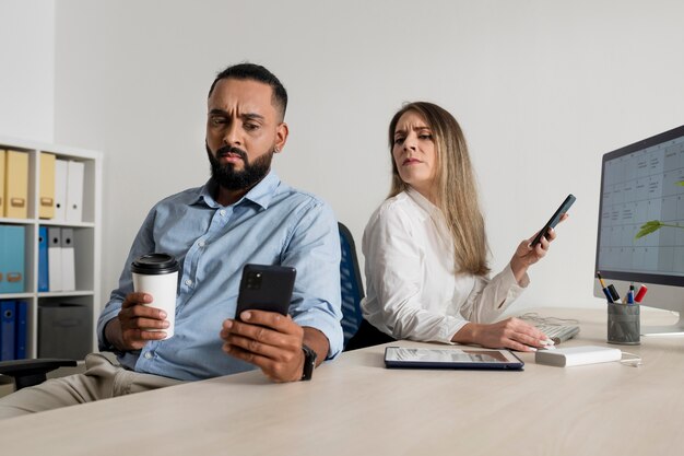 男性と女性が自分の携帯電話にはまっている