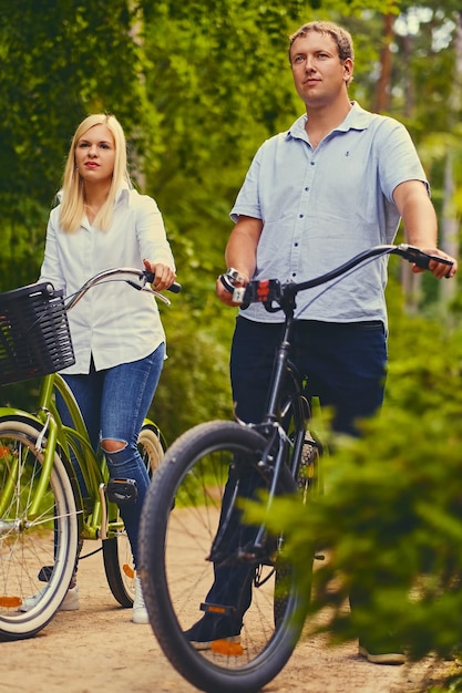 A man and a woman on a bicycle ride in a wilderness park.