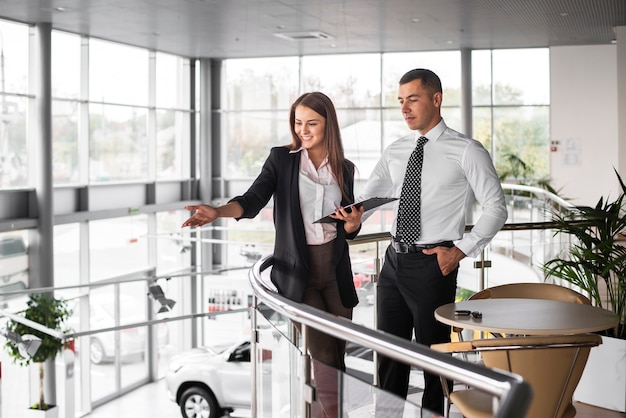 Foto gratuita uomo e donna al concessionario auto insieme