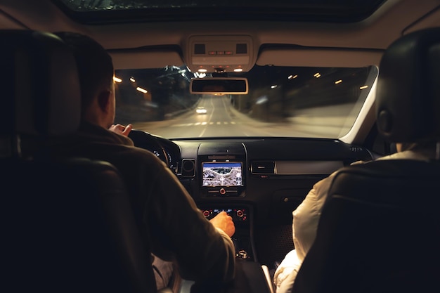 Free photo man and woman in a car at night view from the car