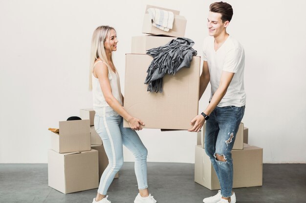 Man and woman carrying carton box