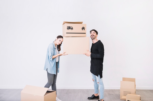 Man and woman carrying moving boxes