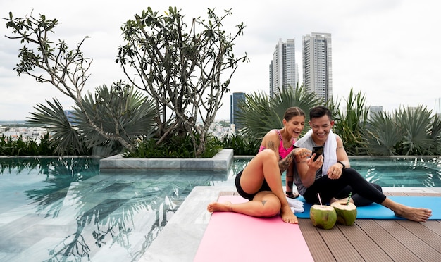 Man and woman checking smartphone after yoga session