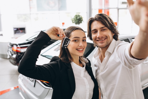 Man and woman choosing a car in a car showroom