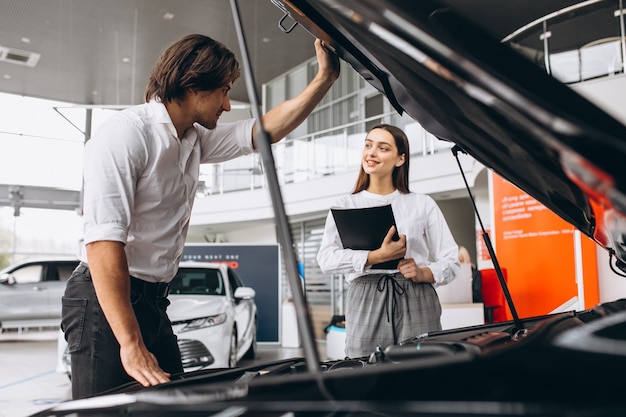 Man and woman choosing a car in a car showroom