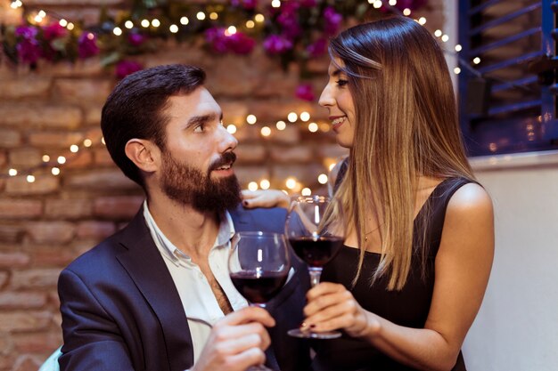 Man and woman clanging glasses of drink 