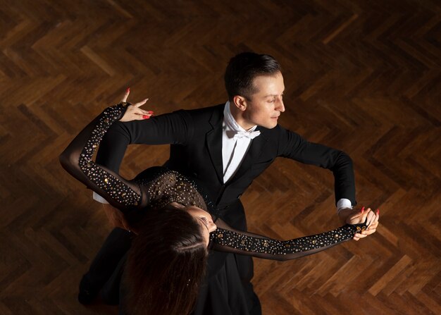 Man and woman dancing together in a ballroom scene