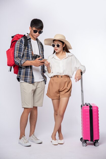 Man and woman dressed up wearing glasses to travel with suitcases