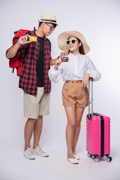 Man and woman dressed up wearing glasses to travel with suitcases