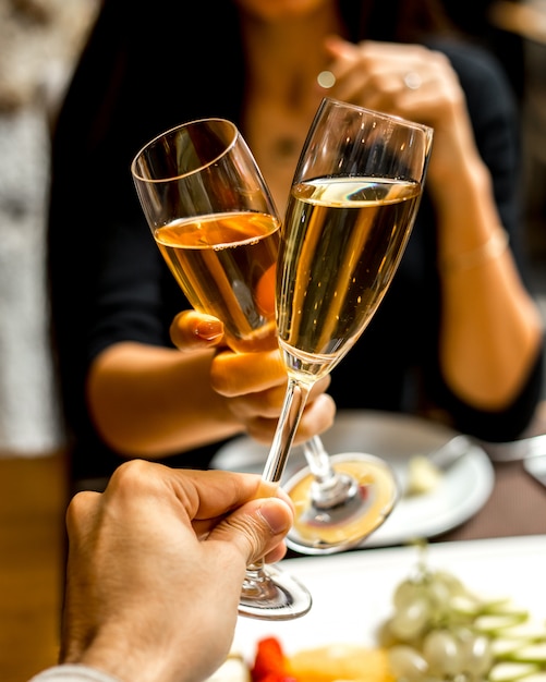 Foto gratuita l'uomo e la donna bevono champagne con un piatto di frutta