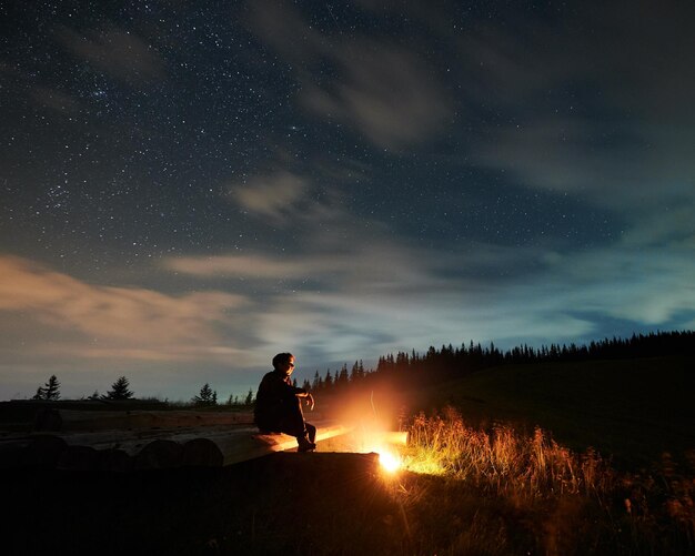 Man or woman enjoying incredible nature and sky with stars