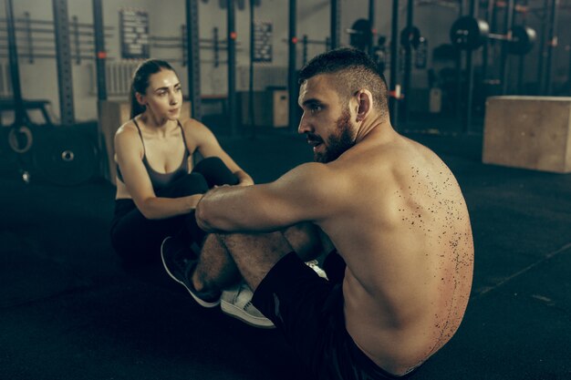 Man and woman during exercises in the fitness gym.