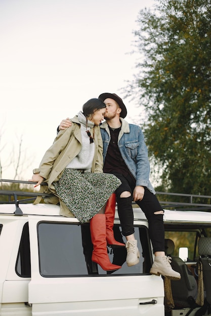 Man and woman in fashion clothes sitting on top of the bus