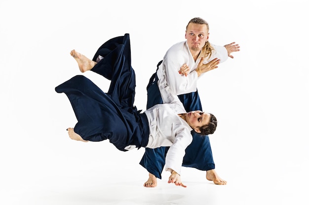 Free photo man and woman fighting and training aikido on white studio wall