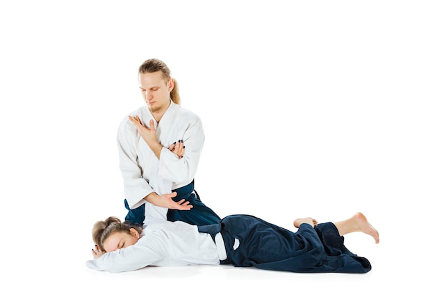 Man and woman fighting and training aikido on white