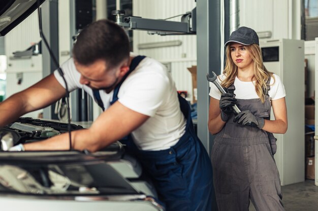 Man and woman fixing car together