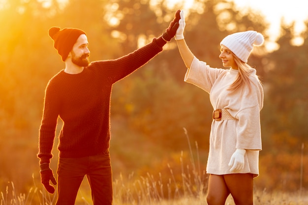 Free photo man and woman high fiving outside