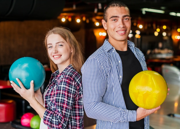 Man and woman holding the bowling balls