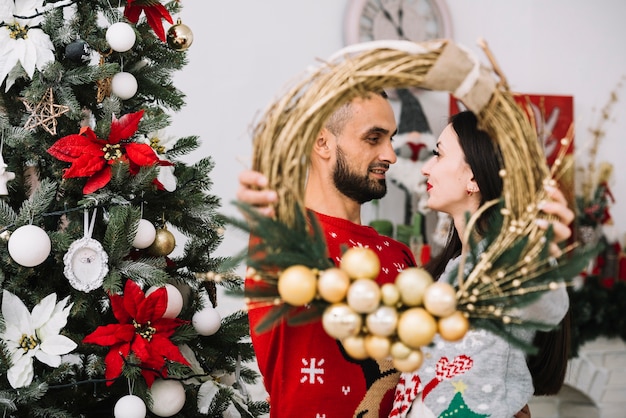 Man and woman holding Christmas wreath