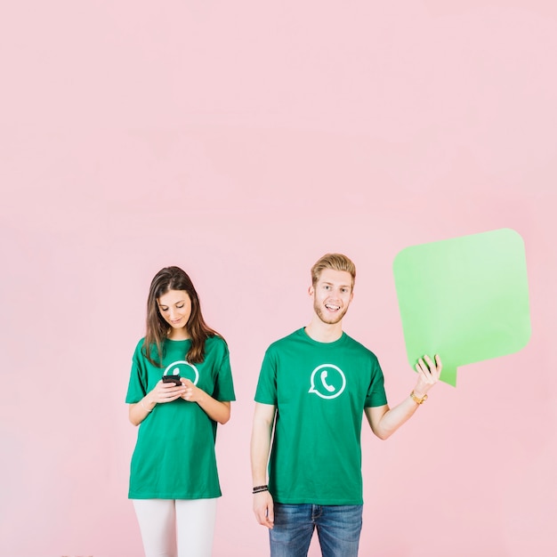 Man and woman holding empty speech bubble and smartphone