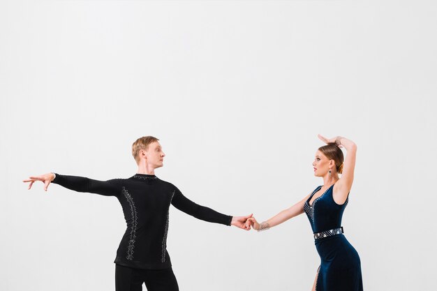 ダンスの間に手を持っている男と女性