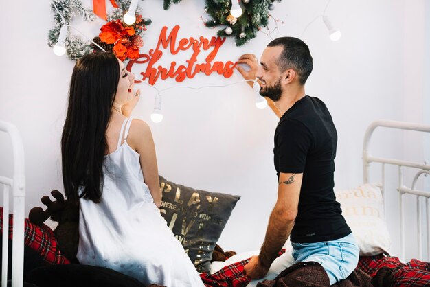 Мужчина и женщина, держащая веселую рождественскую надпись