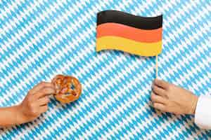 Free photo man and woman holding pretzel and flag