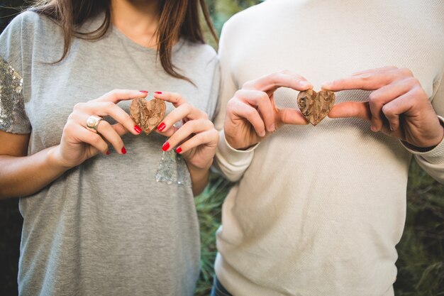 Man and woman holding wooden hearts