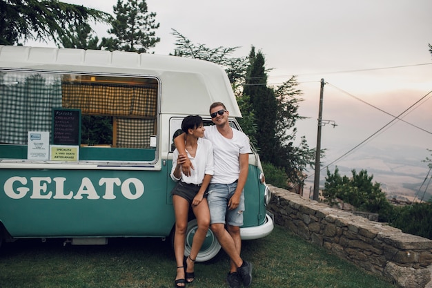 Foto gratuita abbracciare l'uomo e la donna e sorridere seduto in un vecchio autobus