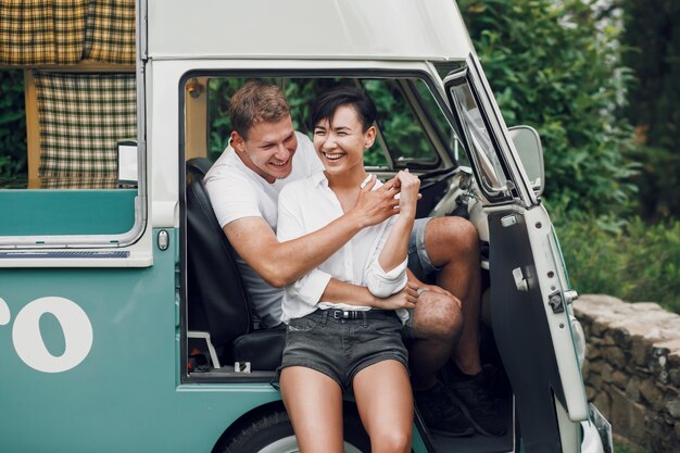 Man and woman hug and smile sitting in an old bus