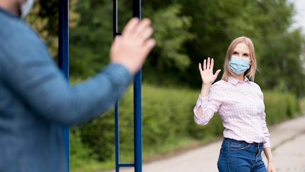 Foto gratuita uomo e donna mantenendo la distanza sociale