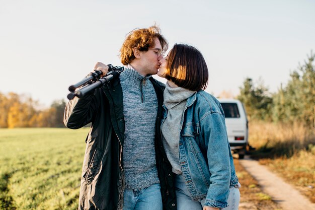 Man and woman kissing close to their van