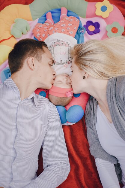 Man and woman kissing their baby