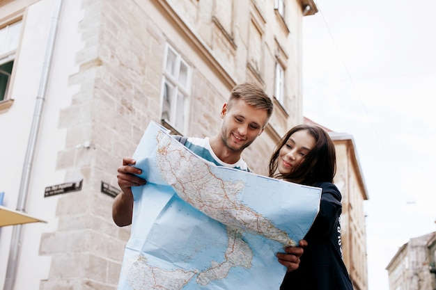 Мужчина и женщина смотрят на карту, стоящую в старом городе
