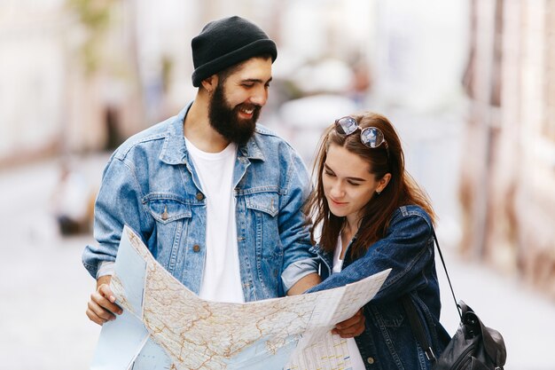 Мужчина и женщина смотрят на карту, стоящую где-то в старом городе