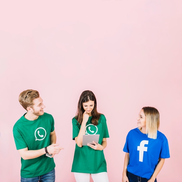 Man and woman looking at each other while her friend using digital tablet