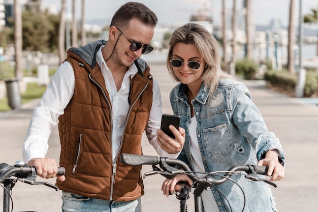 Man and woman looking at a phone next to their bikes