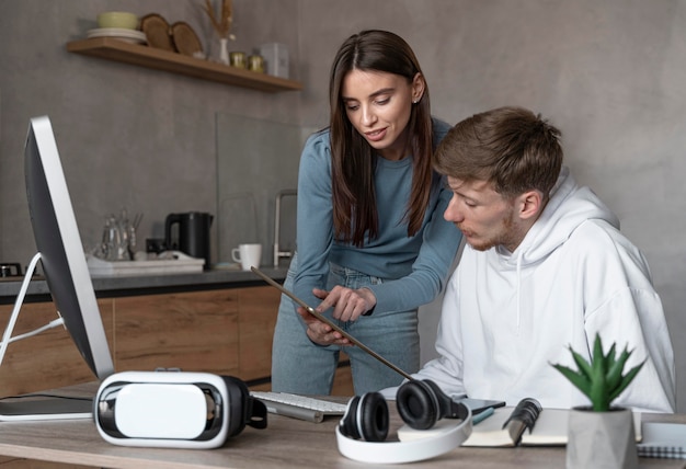 Free photo man and woman looking at tablet together at work