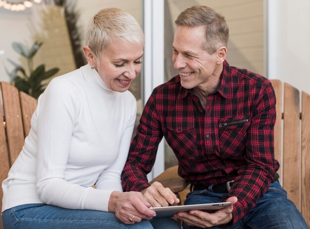 Man and woman looking on their tablet