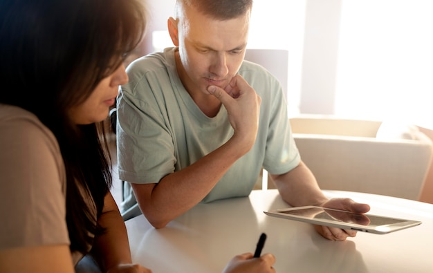 Man and woman making shopping list with tablet