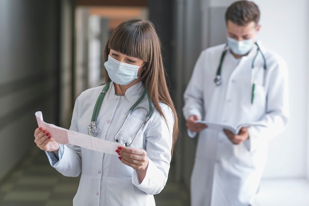 Free photo man and woman medics with papers