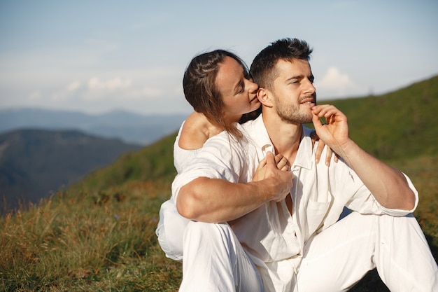 산에서 남자와 여자. 일몰 사랑에 젊은 부부. 파란 드레스에 여자입니다.