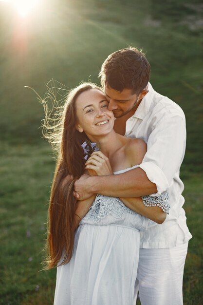 Man and woman in the mountains. Young couple in love at sunset. Woman in a blue dress.