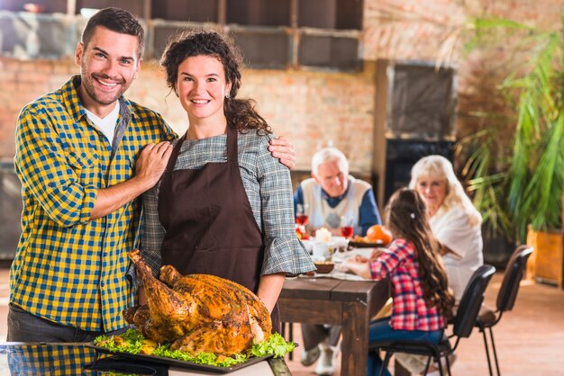 Man and woman near tray with roasted ham